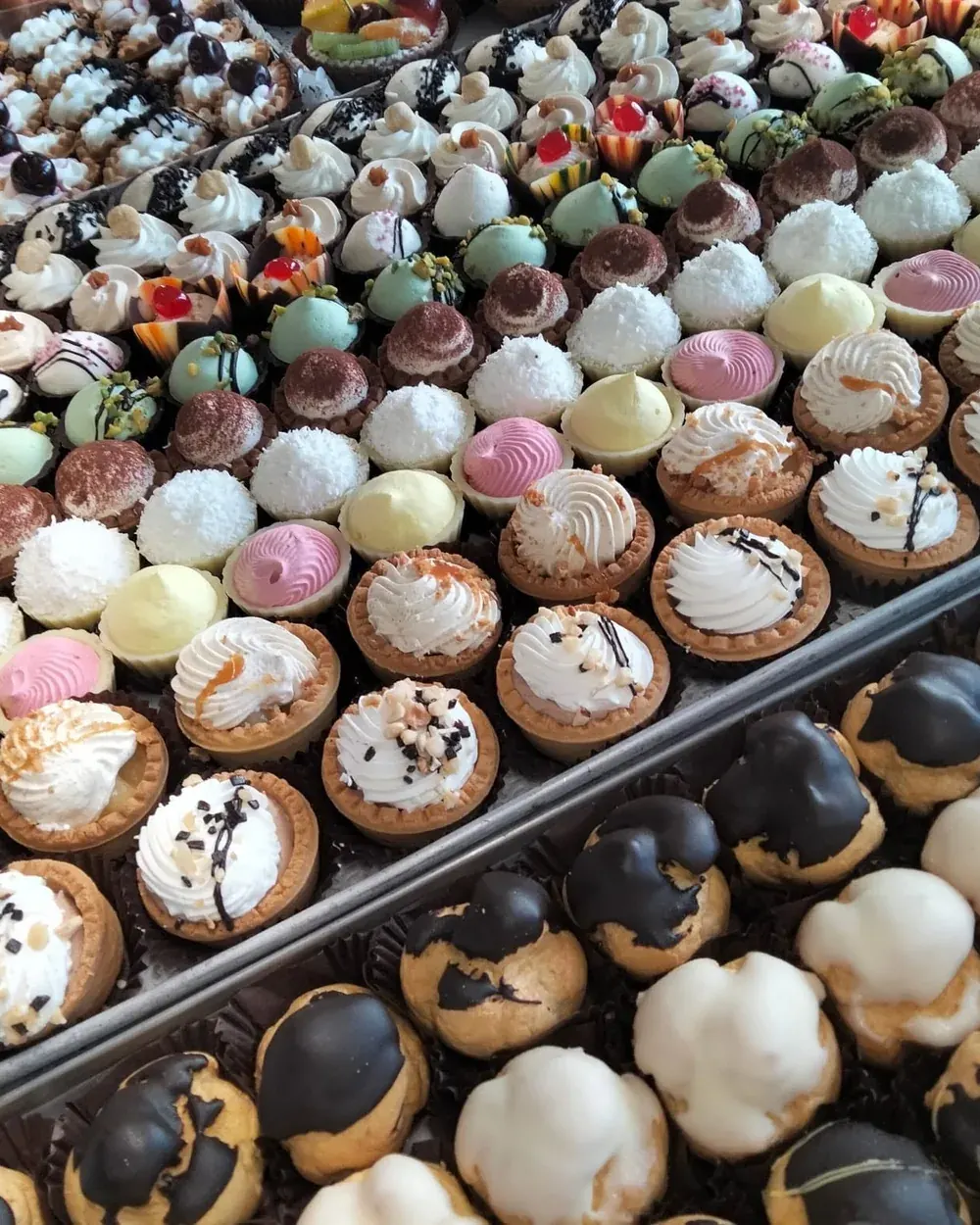 Vassoi di paste mignon e bignè al cioccolato